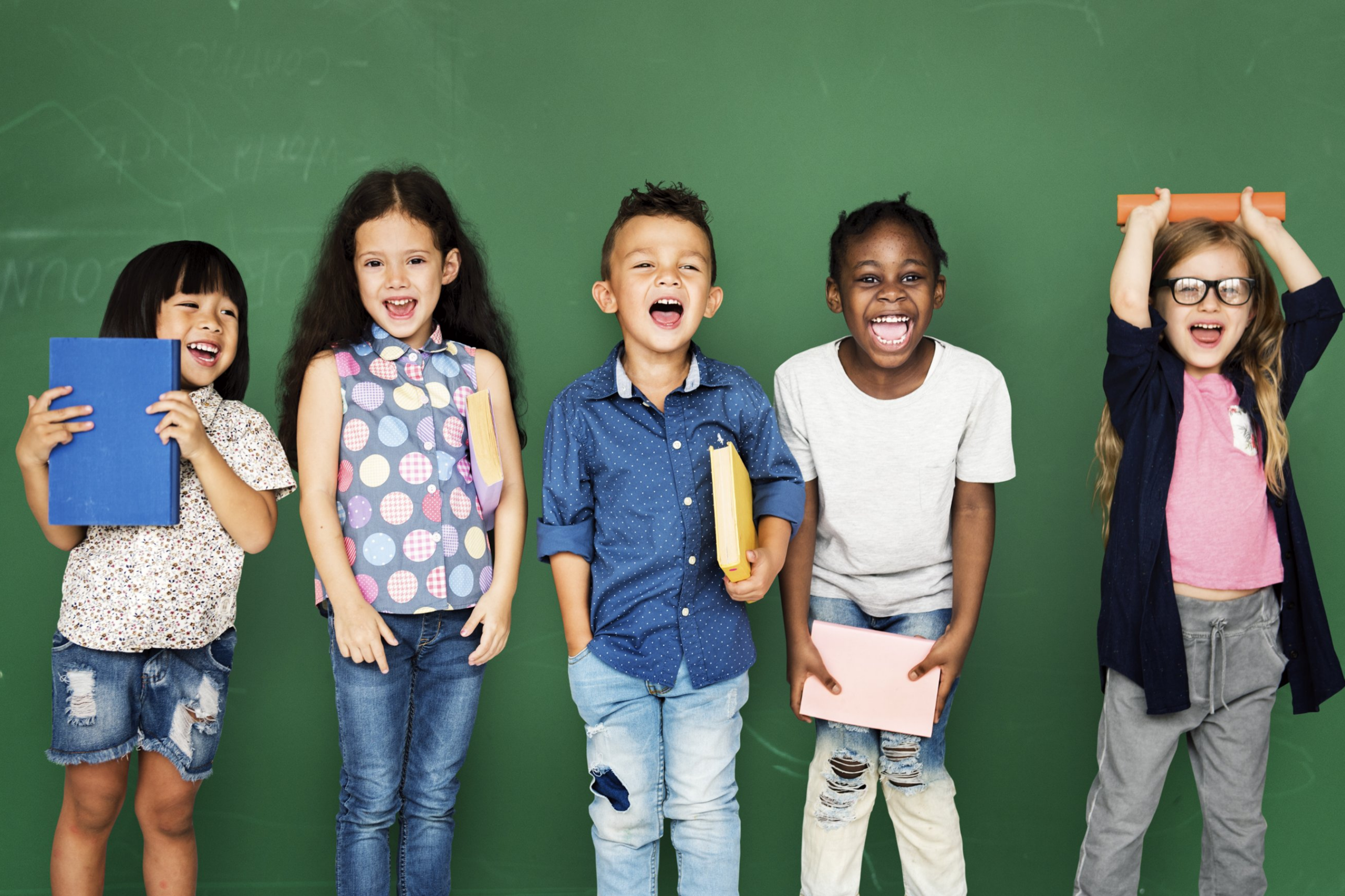 Children laughing in front of chalkboard