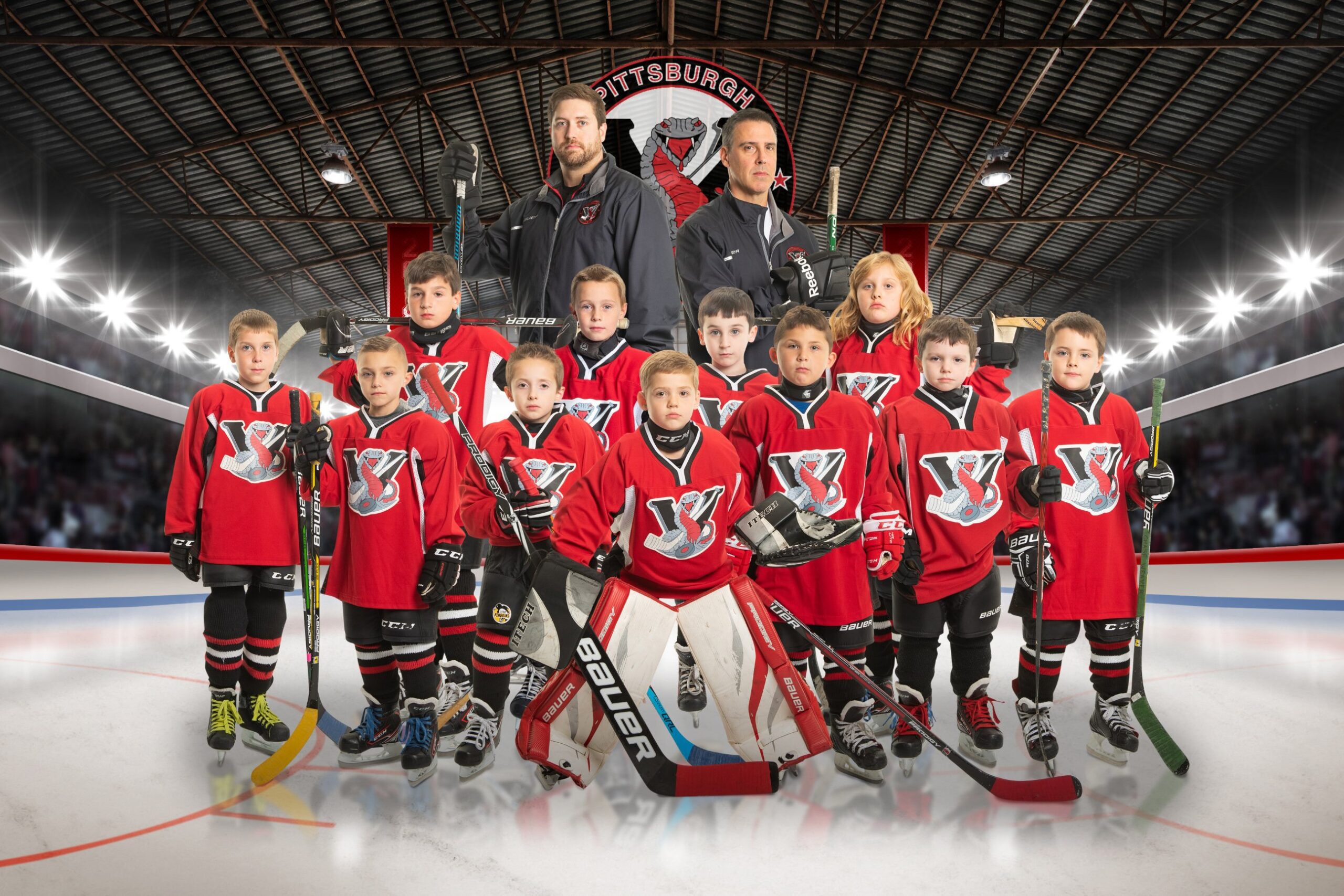 Kids in red hockey jerseys with coaches
