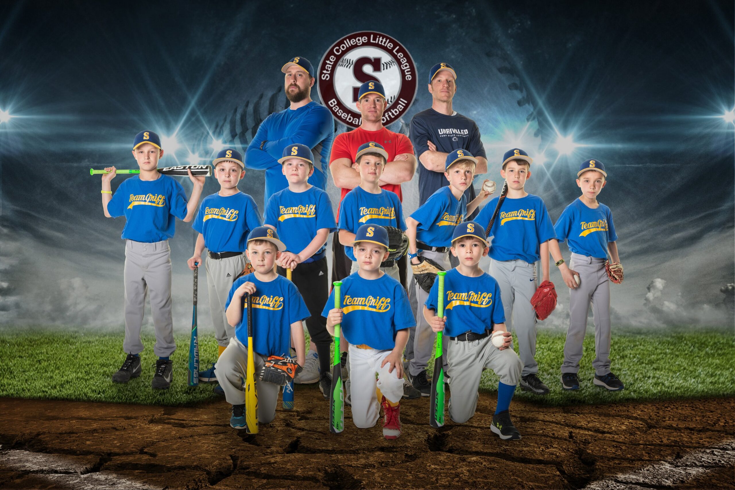 Kids in blue uniforms with bats