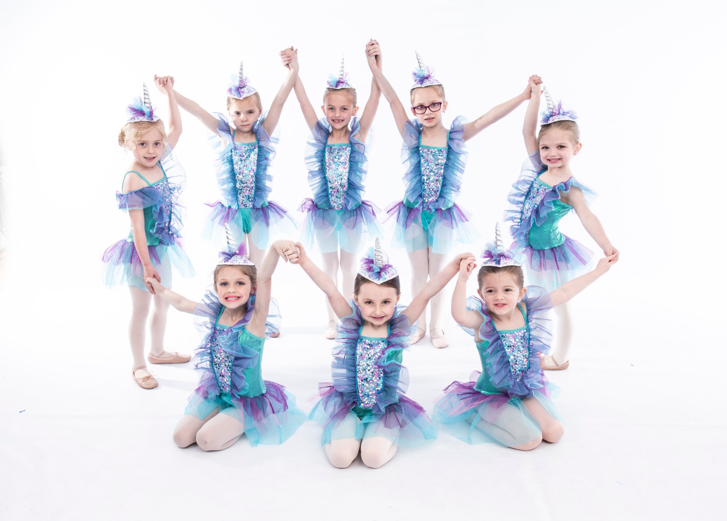Children in unicorn costumes posing together