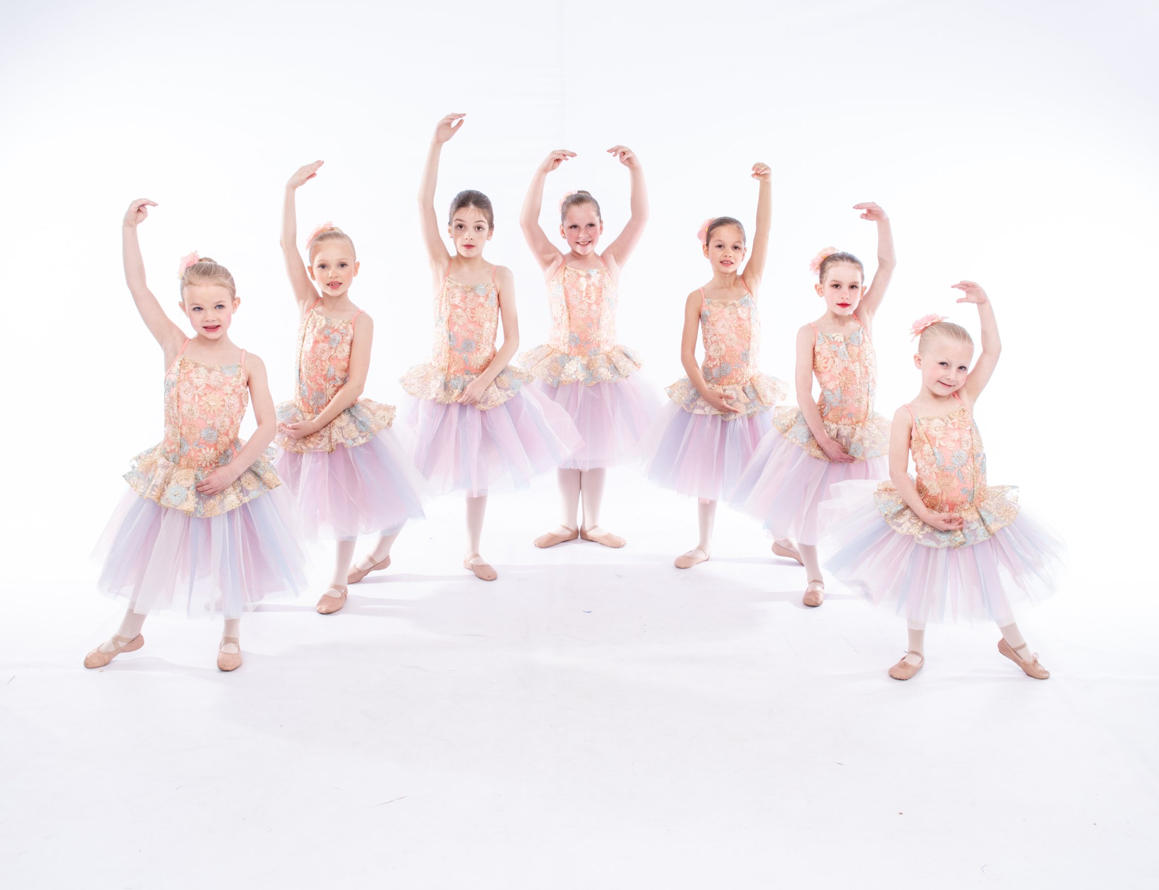 Young dancers in pink tutus pose