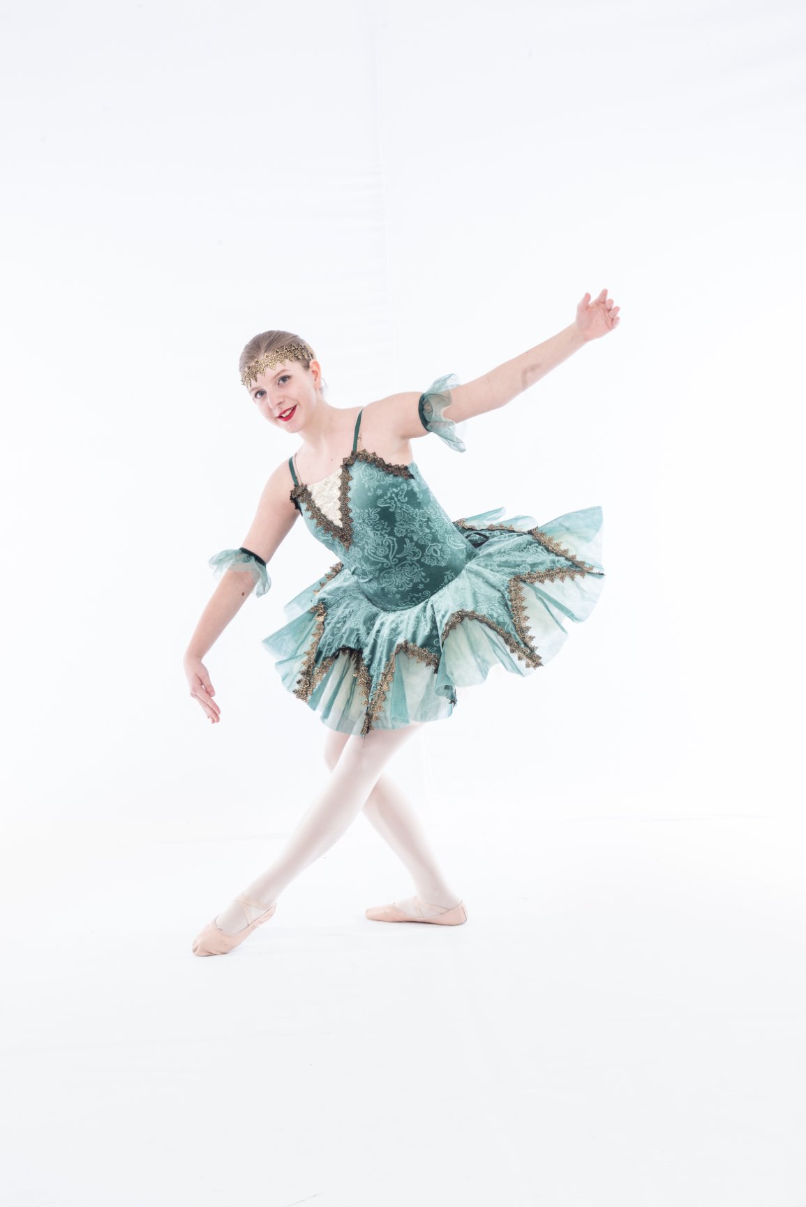 Ballerina in green tutu posing gracefully