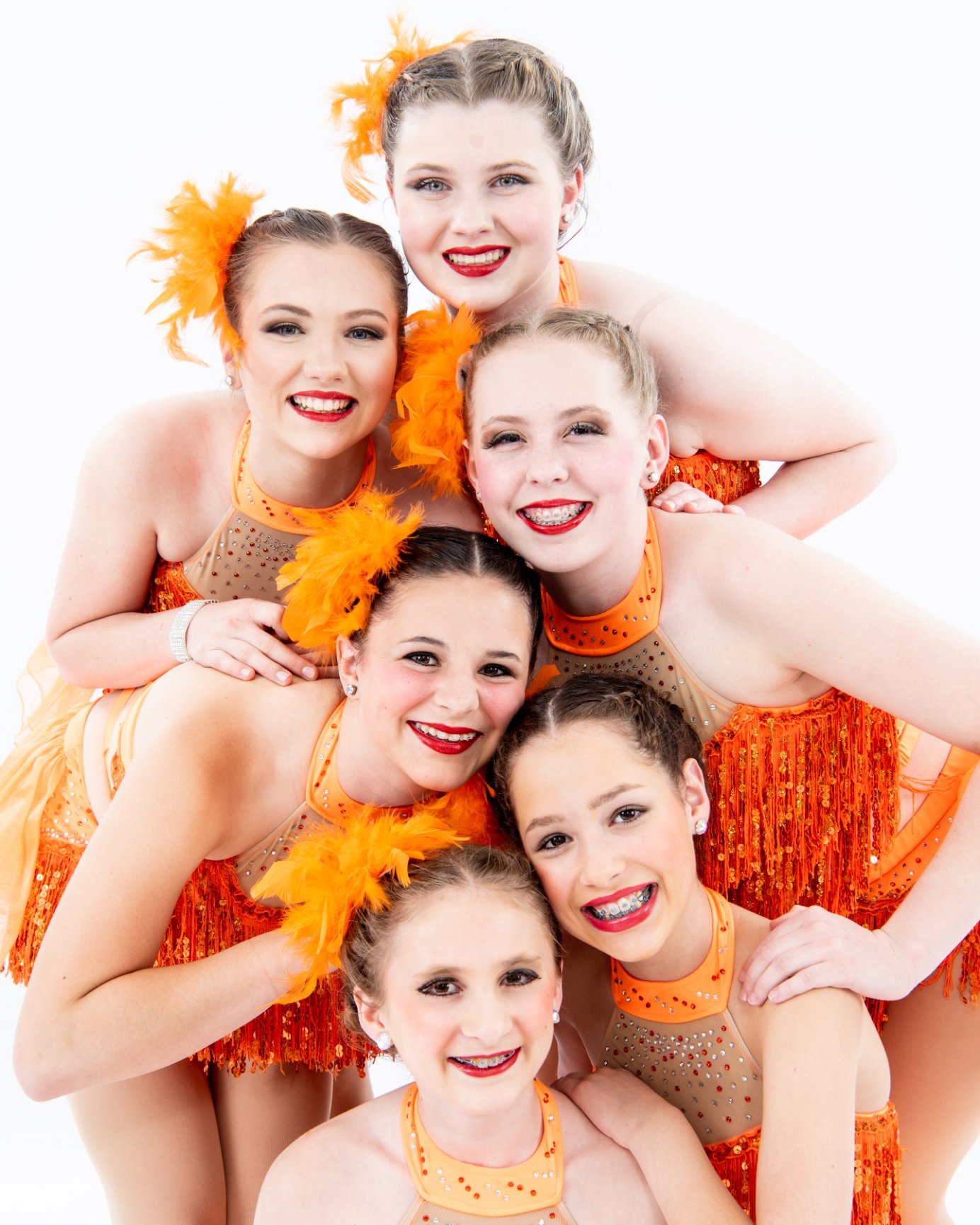 Smiling dancers with orange feathers