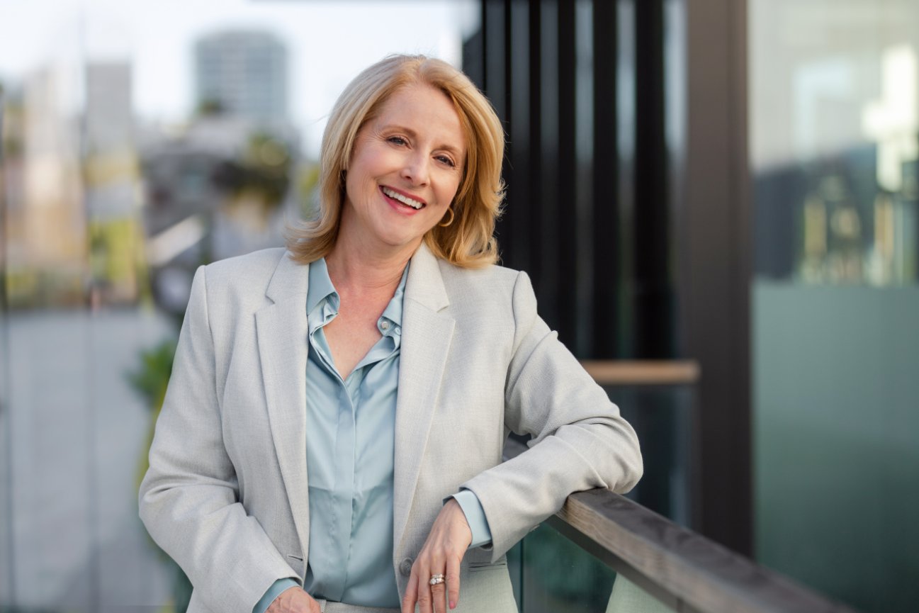 Smiling woman in a light gray blazer